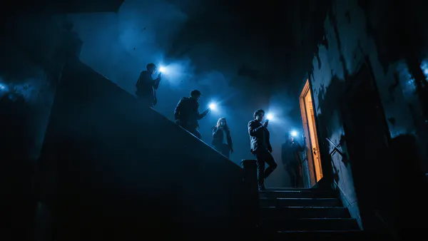 A group of five young investigators descend a shadowy staircase into an abandoned mansion, flashlights cutting through darkness, ready to uncover sinister secrets.